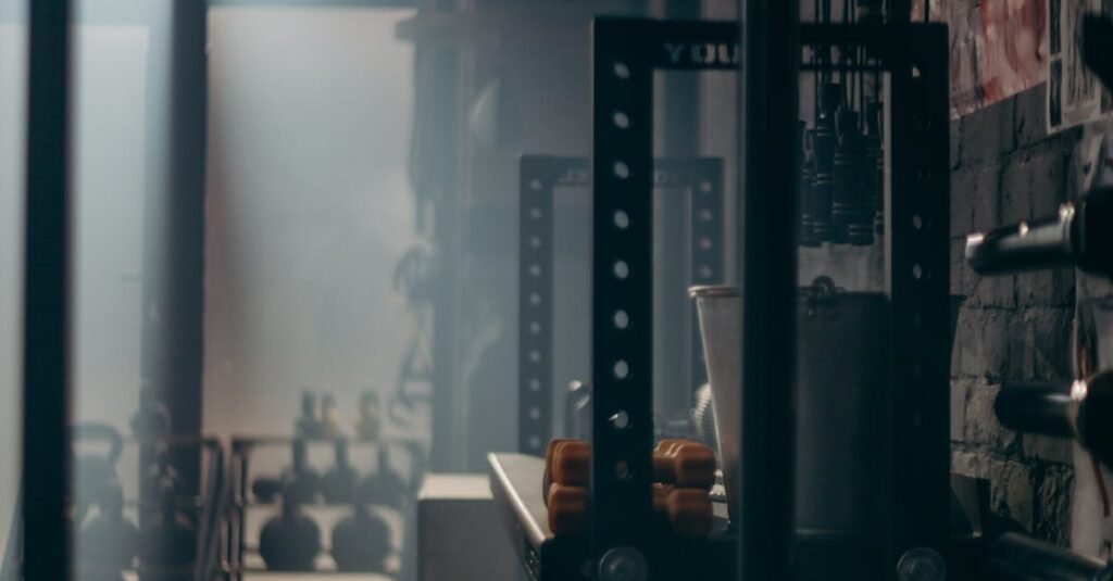 A dark and atmospheric gym interior showcasing weights and fitness equipment with dramatic lighting.
